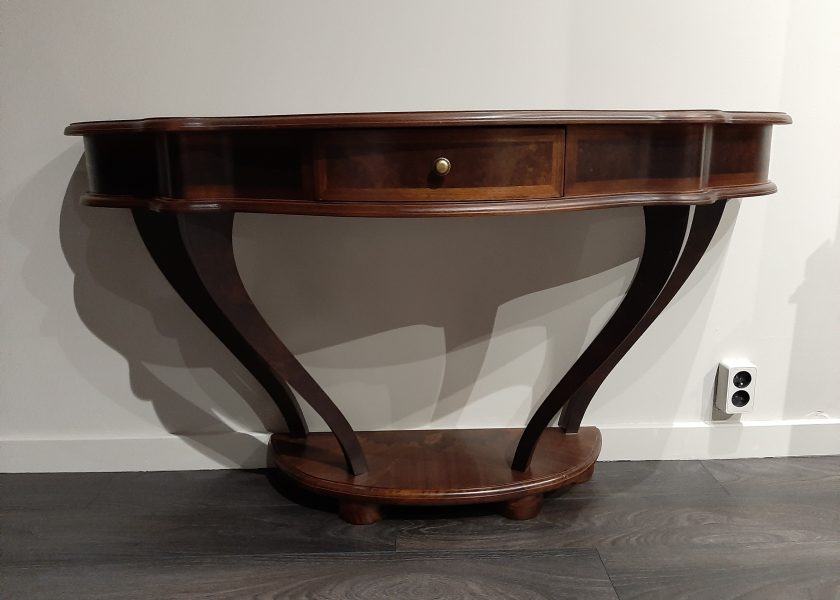 A stylish console, made of wood, the base has four curved legs that support the drawers and top.