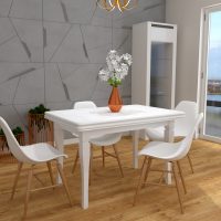 Wizualizacja salonu przedstawiająca biały stół z kompletem czterech krzeseł o plastikowym oparciu z nogami drewnopodobnymi. Na ścianie imitującej beton umieszczona zostałą witrynka oraz komoda.