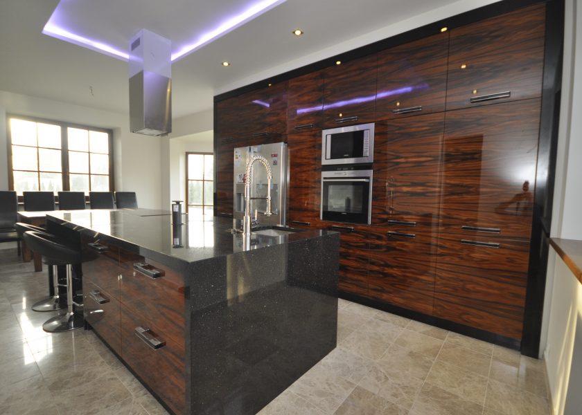 A modern kitchen, open to the living room. Furniture made of lacquered fronts.