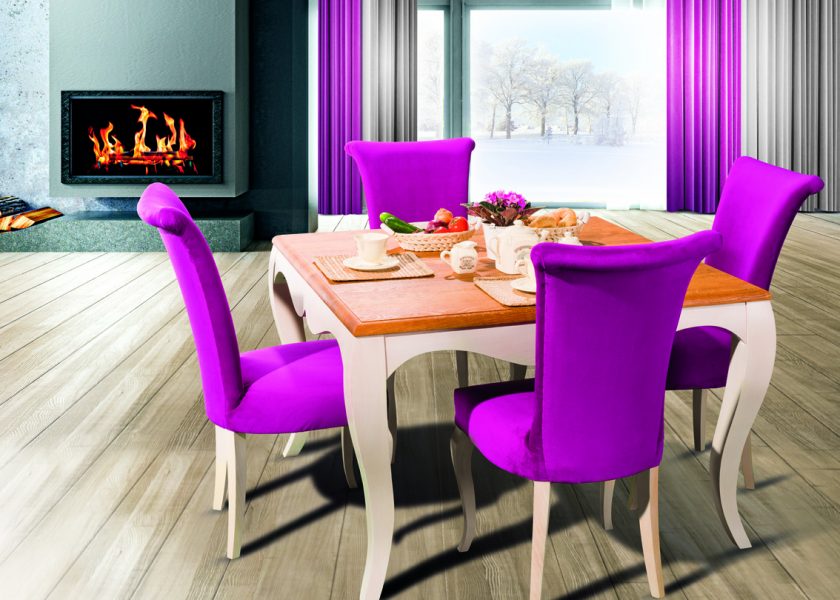 Drewniany stół oraz cztery drewniane krzesła z różową tapicerką.