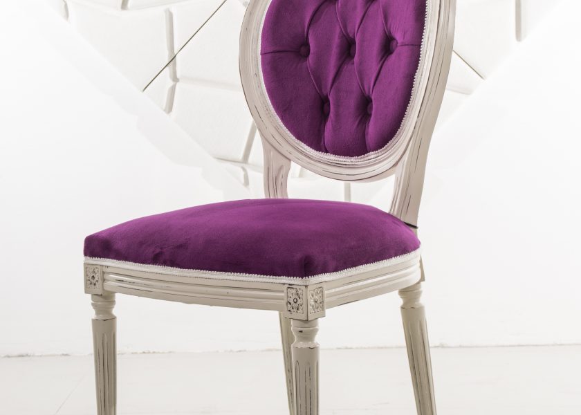 Stylowe krzesło z litego drewna z fioletową tapicerką.