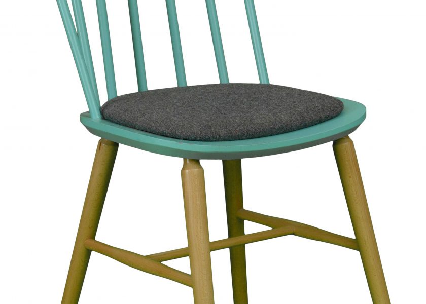 The photo shows a chair model EurosB from the Jura collection. The chair has wooden legs and an upholstered seat.