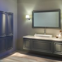 Wnętrze nowoczesnej łazienki z białą umywalką nablatową, dużym lustrem, dwiema lampami elektrycznymi i meblami.